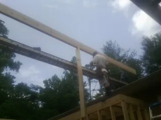 Carpenter setting a ridge beam over a new addition frame — Ice Dam Removal by Roofing Brothers in Ixonia