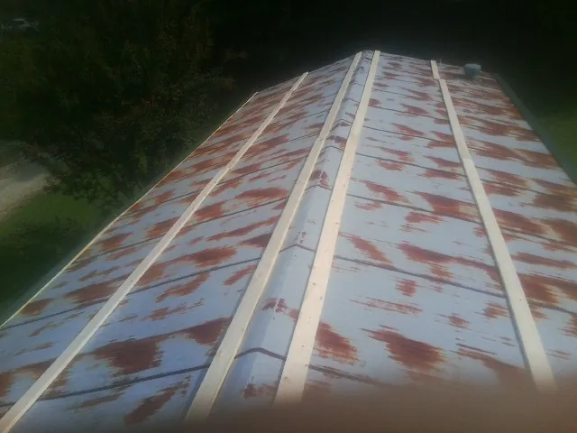Rusted metal roof panels with new wood purlins before replacement — Storm Damage Roof Repair in Ixonia by Roofing Brothers