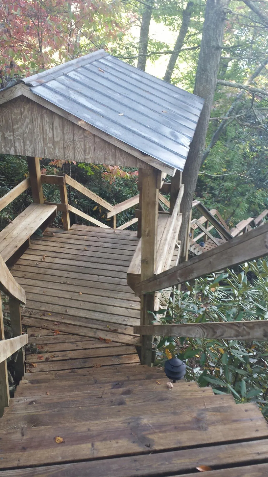 Metal roofed shelter over wooden steps on a wooded walkway — Skylight Repair & Installation work by our crew in Ixonia