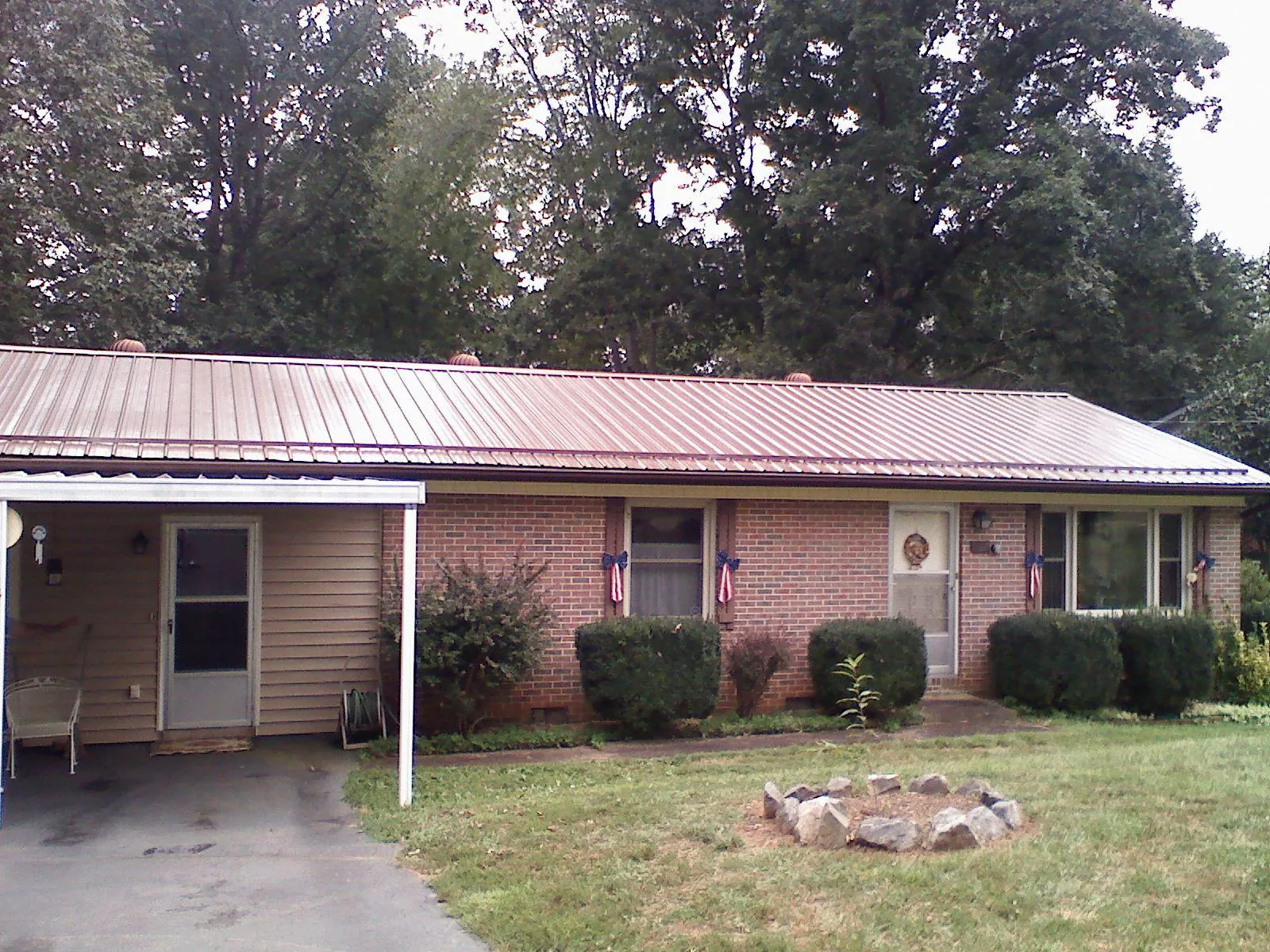 Bronze metal roof and carport on a brick ranch home — Roof Repair work by our crew in Ixonia